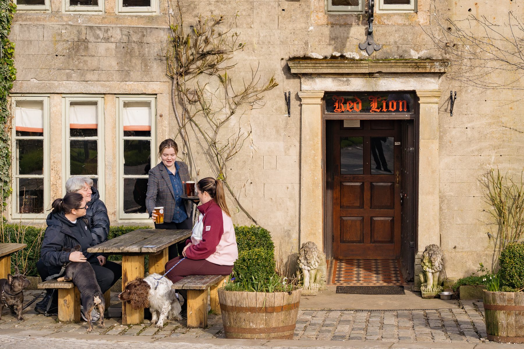 The Red Lion pub exterior with guests and dogs