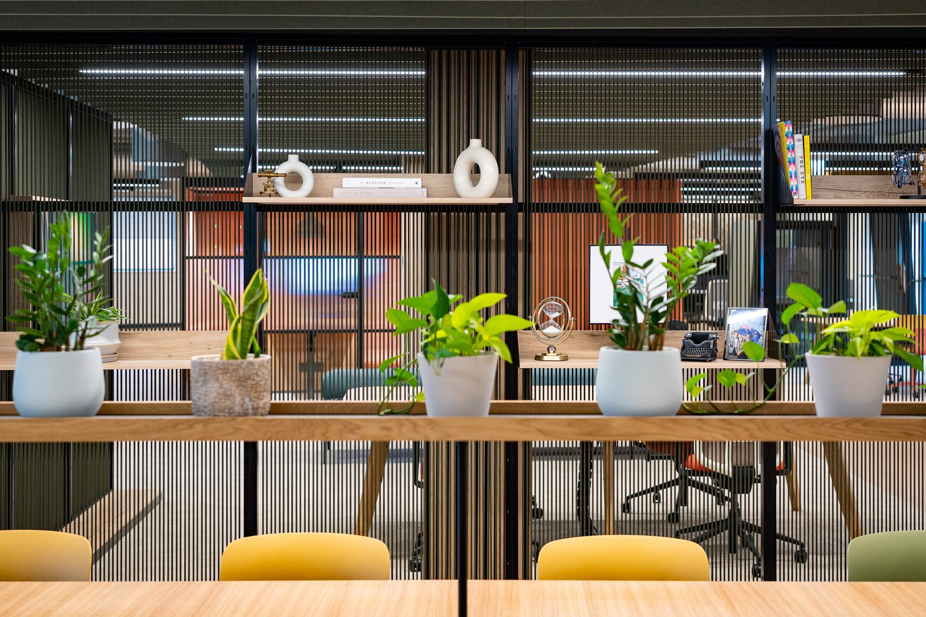 Bright workplace café with colourful chairs and pendant lighting