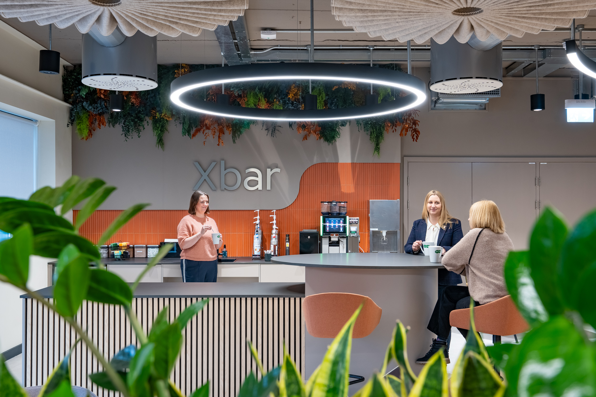 Modern workplace café with ring-light pendants, commercial interior photography