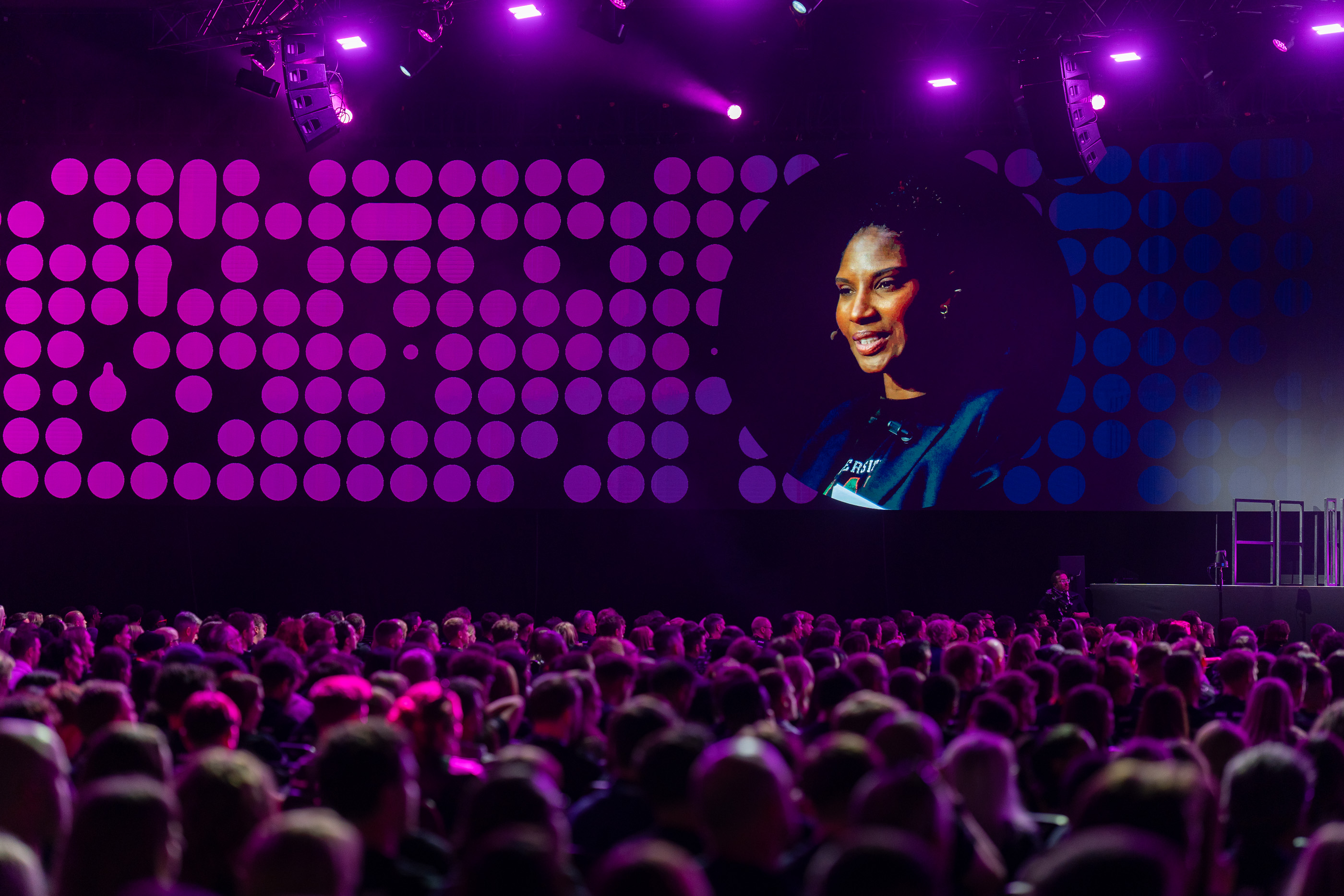 Wide view of a packed conference audience at a business event