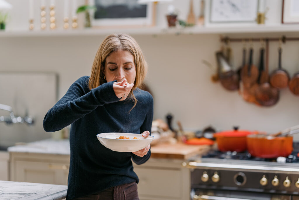 A woman eating in a kitchen